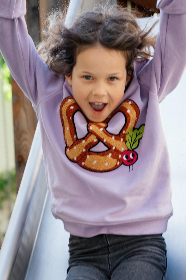 Girl sliding with Brezel Sweatshirt in Lavendel