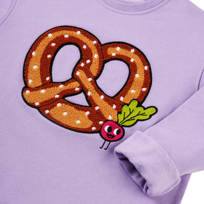 Detailansicht: Hochwertige Stickerei Brezel mit kleinen Radieschen auf lavendelfarbenem CHIO MI Kindersweatshirt – Close-up pretzel and radish embroidery detail – Détail de broderie bretzel et radis de haute qualité.