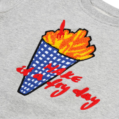 Detailansicht: „Make it a Fryday“ Slogan und hochwertige Pommes-Tüten Stickerei auf CHIO MI Sweater – Close-up French Fries embroidery detail – Détail de broderie frites de haute qualité.