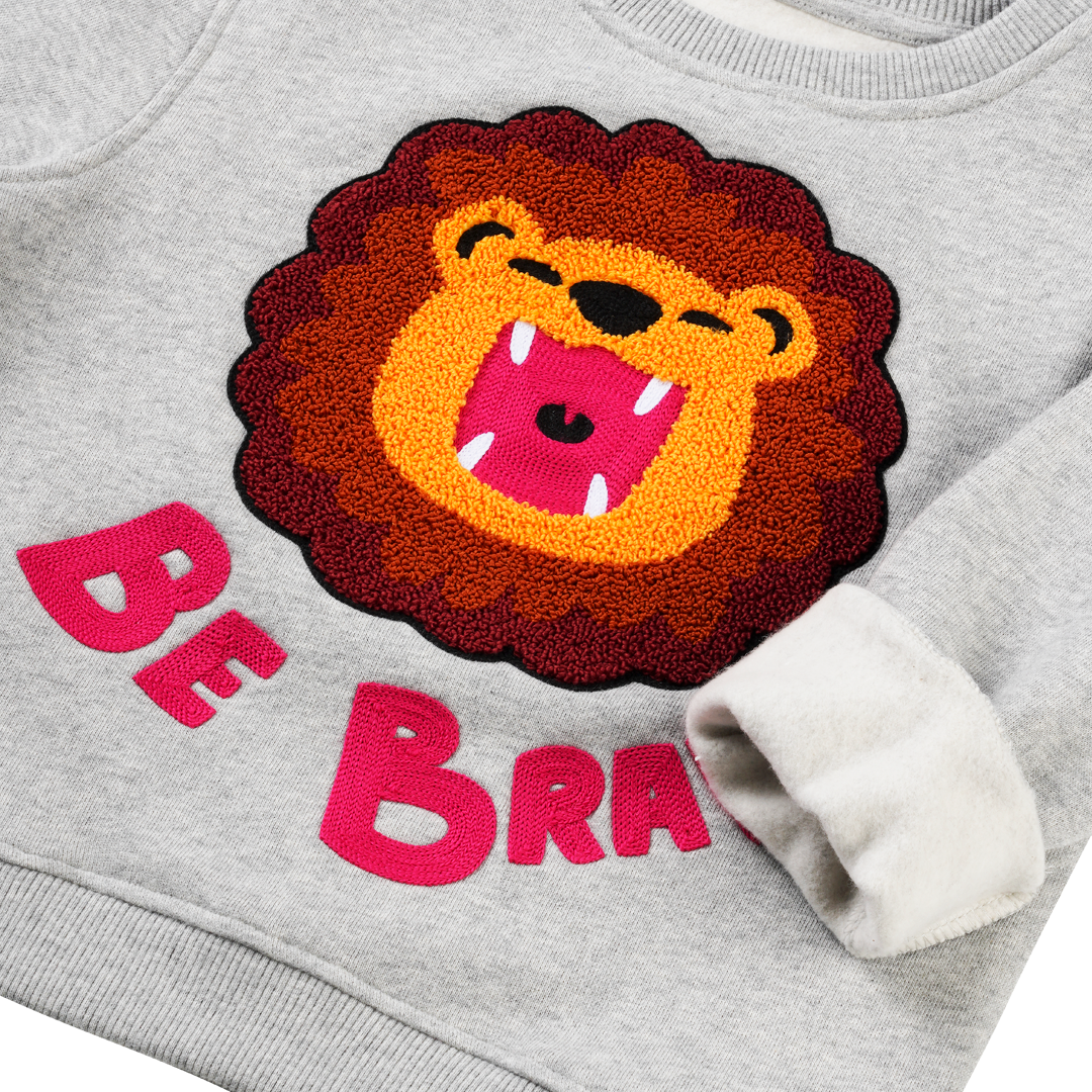 „Be Brave“: Kind im CHIO MI Löwen Sweatshirt – Das ideale Mutmacher-Geschenk für die Einschulung oder den Kindergarten – Kids wearing "Be Brave" lion outfit – Enfant portant le sweat lion "Be Brave" comme cadeau de rentrée scolaire.
