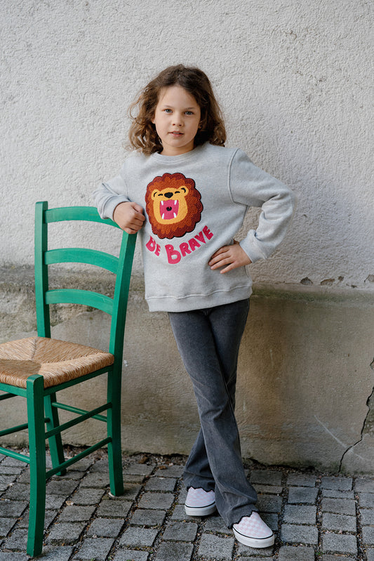 „Be Brave“: Kind im CHIO MI Löwen Sweatshirt – Das ideale Mutmacher-Geschenk für die Einschulung oder den Kindergarten – Kids wearing "Be Brave" lion outfit – Enfant portant le sweat lion "Be Brave" comme cadeau de rentrée scolaire.