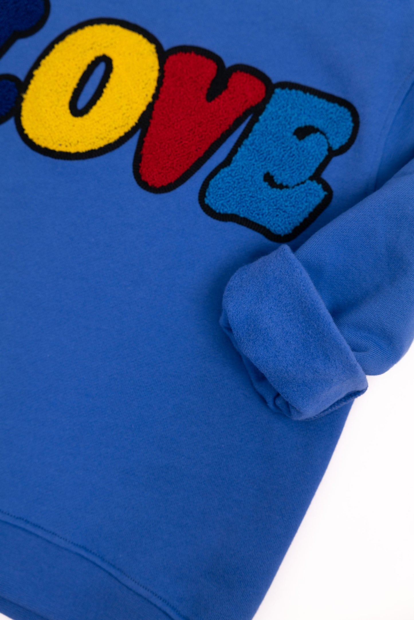 Detailansicht: Hochwertige 3D-Stickerei der LOVE Signature – Ein täglicher Reminder: There can never be enough love – Hochwertige Verarbeitung auf Bio-Baumwolle – Close-up LOVE embroidery detail – Never enough love – Détail de broderie LOVE de haute qualité.