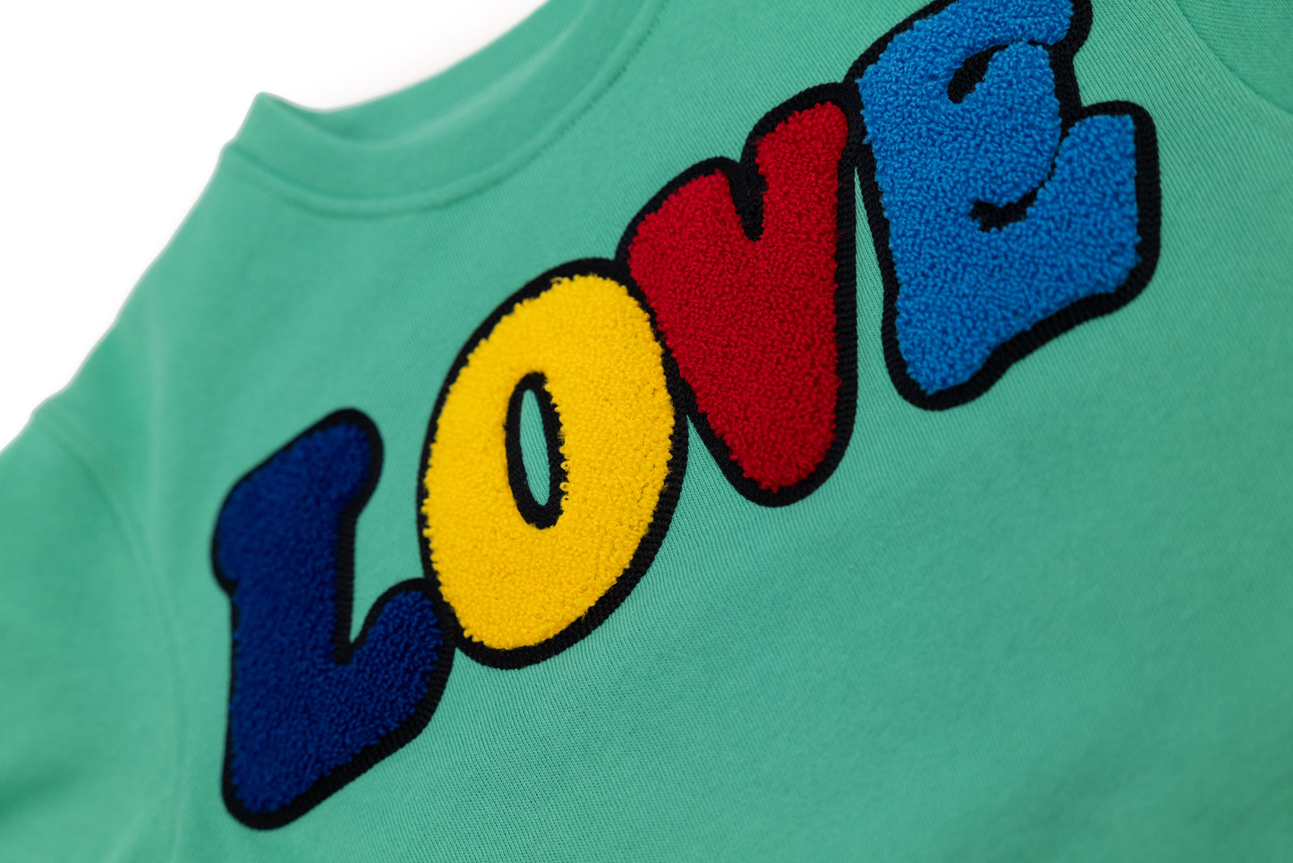 Detailansicht: Hochwertige 3D-Stickerei der LOVE Signature – Edles Design mit tiefem Ausdruck von Zuneigung und Verbundenheit – Close-up LOVE embroidery detail – Inspired by the iconic LOVE sculpture – Détail de broderie LOVE de haute qualité.