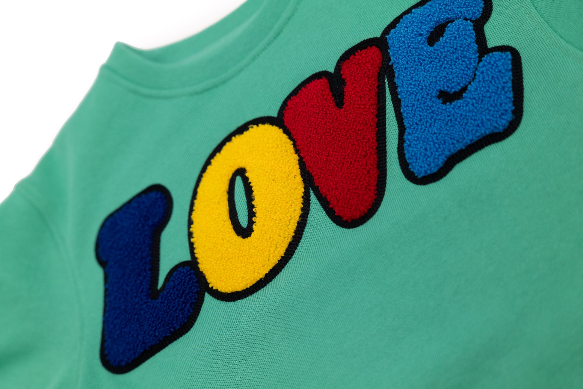 Detailansicht: Hochwertige 3D-Stickerei der LOVE Signature – Edles Design mit tiefem Ausdruck von Zuneigung und Verbundenheit – Close-up LOVE embroidery detail – Inspired by the iconic LOVE sculpture – Détail de broderie LOVE de haute qualité.